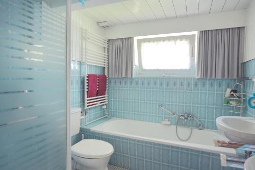 a bathroom with a tub and a toilet and a sink at Urlaub im Friesenhaus in Langenhorn