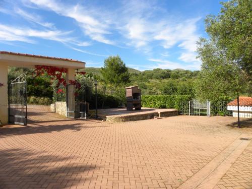 a park with a bench and a fence and trees at Seamoon Residence in Marina di Camerota