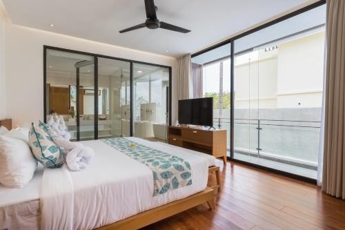 a bedroom with a bed and a flat screen tv at Villa Damar Canggu by Nagisa Bali in Canggu