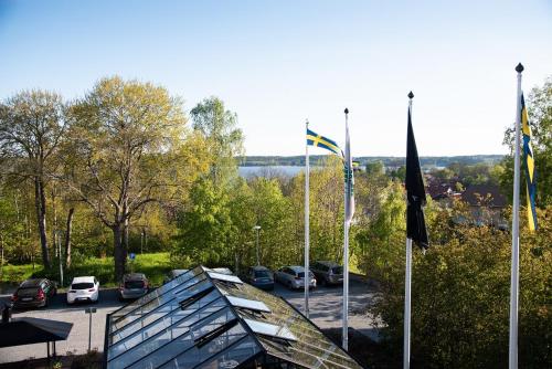 a group of cars parked in a parking lot with flags at Hotell Kristina in Sigtuna