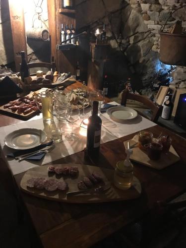 a table with plates of food and a bottle of wine at Bed & Breakfast Casa Marinella in Lenna