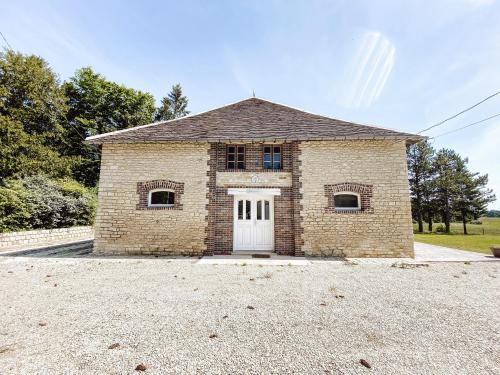 a brick building with a white door and windows at Le Val Suzenay in Vendeuvre-sur-Barse