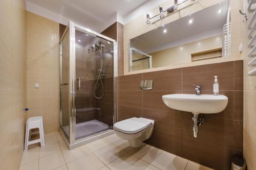 a bathroom with a toilet and a sink and a shower at Promenada I, Sun & Snow in Świnoujście