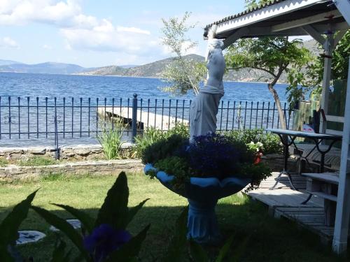 a statue of a woman standing next to the water at Blue Dreams in Almiropótamos