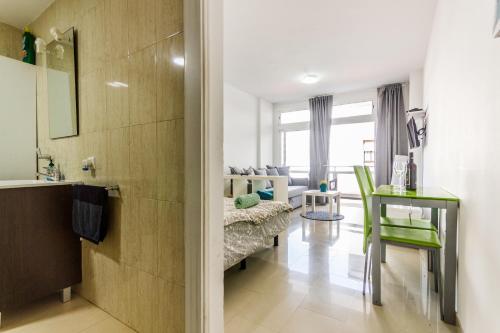 a bathroom with a sink and a living room at Apartment Bonamar in Las Palmas de Gran Canaria