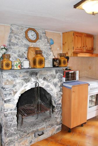 a stone fireplace with a clock on top of it at CASE CARMELI - Primula in Triora