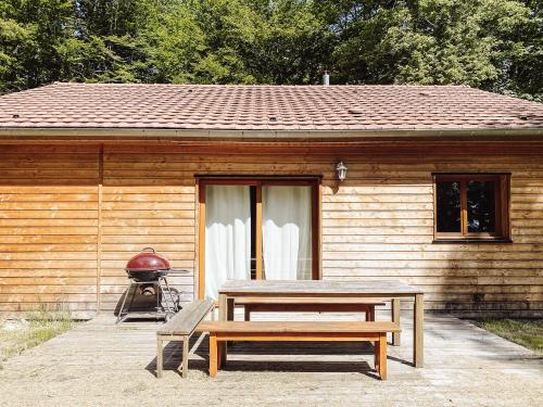a picnic table and a bench in front of a cabin at Le Val Suzenay in Vendeuvre-sur-Barse