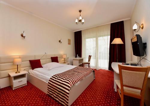 a hotel room with a bed and a desk at Hotel Lord Dębica in Dębica