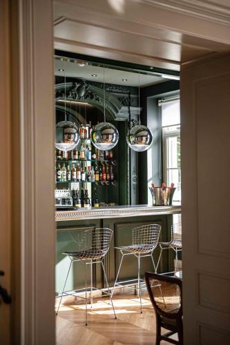 a bar with chairs and a table in a room at Hôtel Mille Pas in Voiron