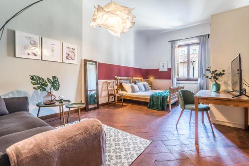 ein Wohnzimmer mit einem Sofa und einem Bett in der Unterkunft Wine Apartments Florence Franciacorta in Florenz