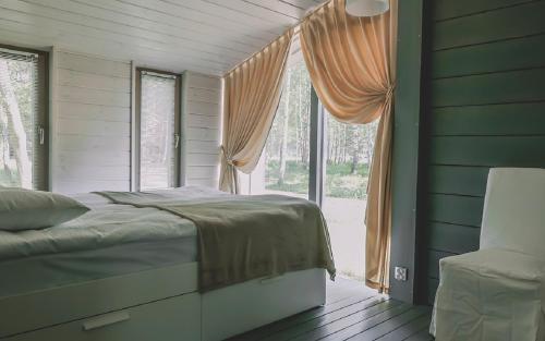 a bedroom with a bed and a large window at Edimonovo Village in Yedimonovo