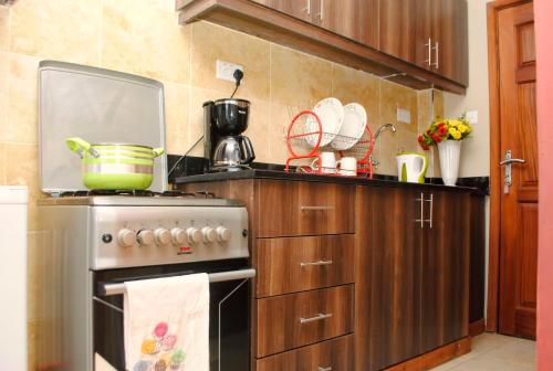 - une cuisine avec cuisinière et pot dans l'établissement West suites home -with a view, à Nairobi