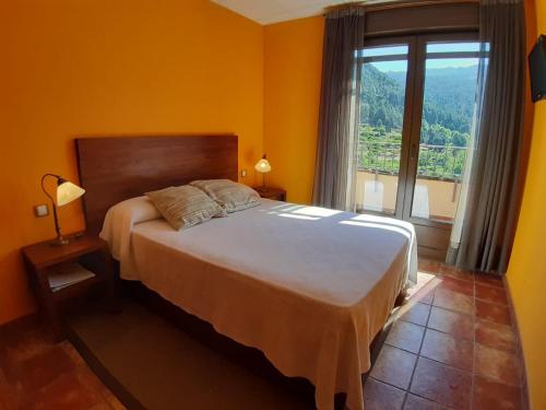 um quarto com uma cama grande e uma janela grande em Hotel Rural Los Molinillos em El Arenal