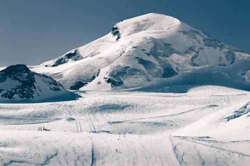a mountain covered in snow with people skiing down it at Hotel Les Amis in Saas-Fee