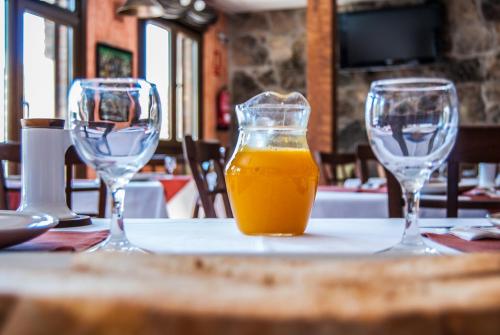 dos vasos de zumo de naranja sentados en una mesa en Hotel Rural Los Molinillos en El Arenal