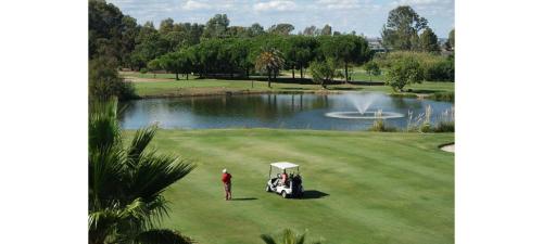 um homem de pé num campo de golfe com um carrinho de golfe em La Quinta I by HOMA em Isla Canela