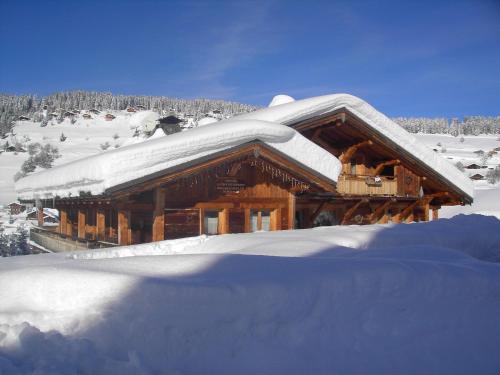 a log cabin with snow on the roof at La Ferme des Georgières "Séjour en tout compris" in Notre-Dame-de-Bellecombe