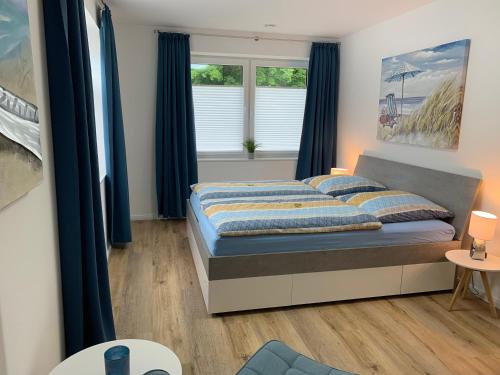 a bedroom with a bed with blue curtains at Mein Ankerplatz in Travemünde