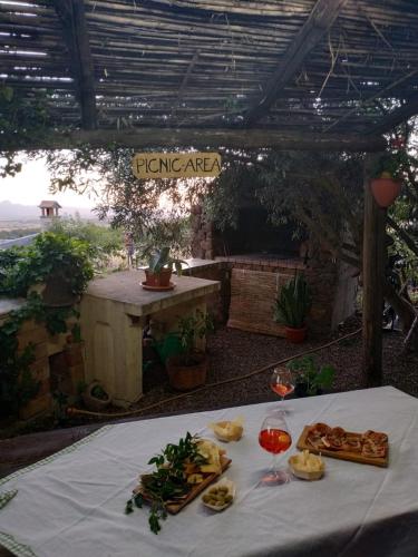 a table with food and glasses of wine on it at B&B Ottoulivi in Sardara