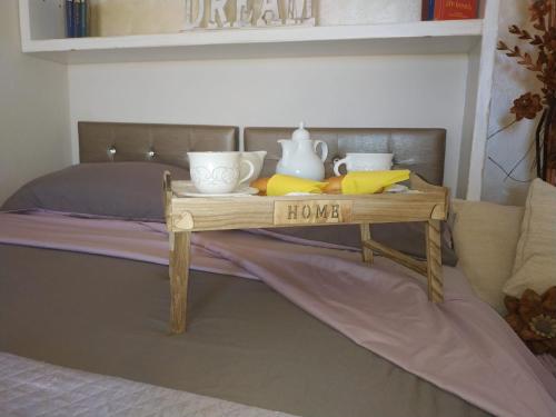 a bed with a table with a sign that says love at B&B Ottoulivi in Sardara