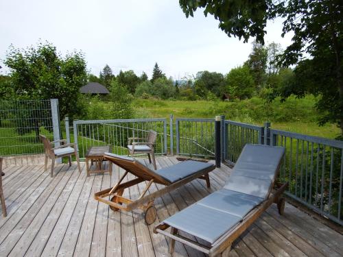 a deck with two chairs and a table and chairs at Apartments Kokl - Adults only in Radovljica