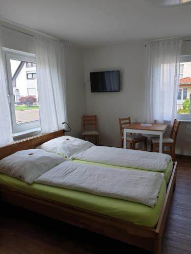 a bedroom with a large bed with a window and a table at Pension Boitz in Rust