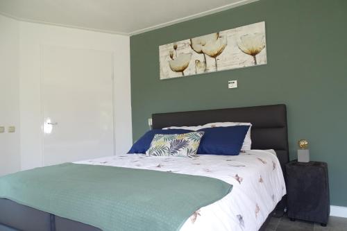 a bedroom with a bed with a green wall at Beekse Brink in Loerbeek