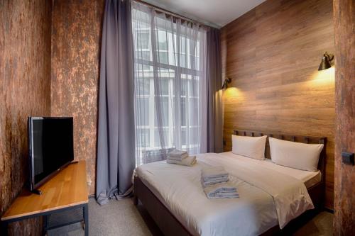 - une chambre avec un lit, une télévision et une fenêtre dans l'établissement Hotel Nova, à Samara