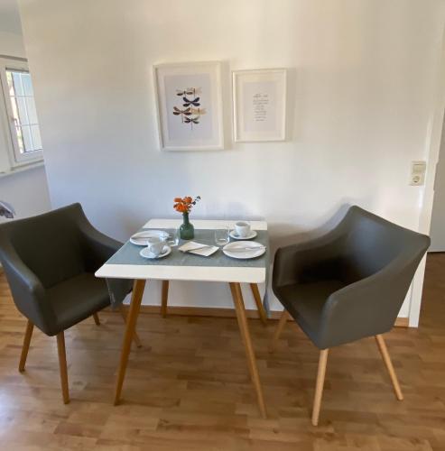 a table with two chairs and a white table and two cups at Haus von Hoegen in Cochem