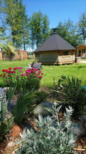 a garden with flowers in front of a gazebo at Le Petit Robinson in Champvert