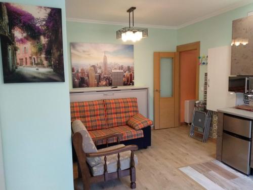 a living room with a couch and a painting on the wall at Residencias Turísticas Matasiete in León