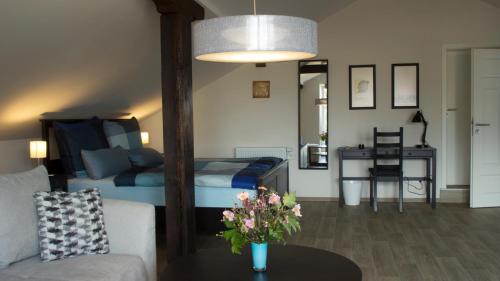 ein Wohnzimmer mit einem Bett und einem Tisch mit Blumen in der Unterkunft Ringelnatz & Lichtwer- Ferienwohnung Wurzen in Wurzen