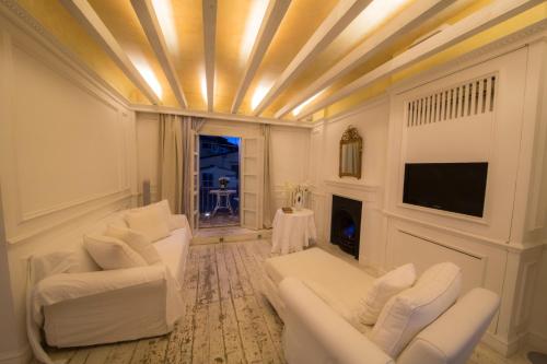 ein Wohnzimmer mit weißen Sofas und einem TV in der Unterkunft White Home in Florenz