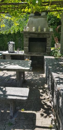 a stone patio with a table and a stone fireplace at Casa Di Vacanza Cevio in Cevio