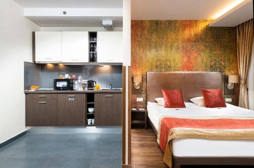 a bedroom with a bed and a kitchen in a room at Opera Garden Hotel & Apartments in Budapest