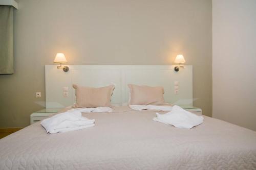 a large white bed with two pillows on it at ELENA APARTMENTS in Masouri