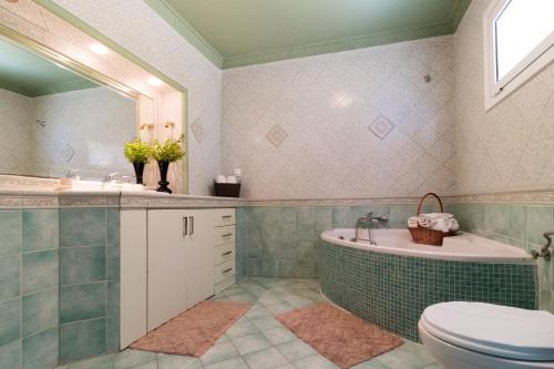 a bathroom with a tub and a sink and a toilet at Traditional Fishing Village Apartments in Boukari