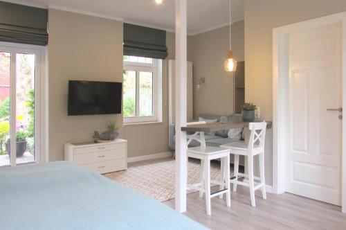 a bedroom with a bed and a table and a television at Gästehaus Muhl in Strukkamp auf Fehmarn