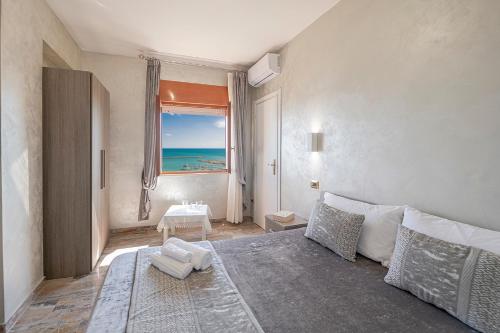 um quarto com uma cama e vista para o oceano em Domus Aurea em Sciacca