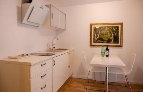 una cucina con lavandino e tavolo con due bottiglie di vino di Storia di Spalato a Spalato (Split)
