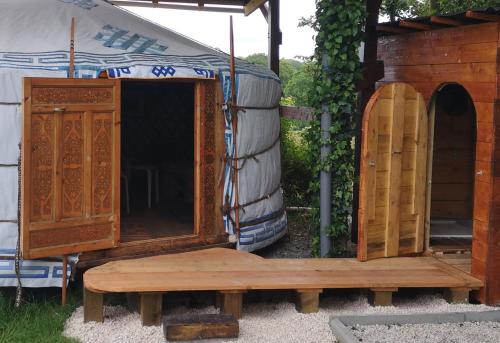 une armoire en bois et un banc à côté d'une tente dans l'établissement Yourte Mont-Saint-Michel, à Jullouville