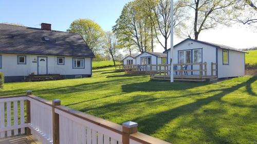 a group of houses in a yard with a fence at Joastorps Bed & Breakfast in Ullared