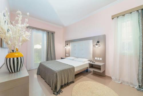 a bedroom with a bed and a large window at Niver Luxury Suites in Lefkada