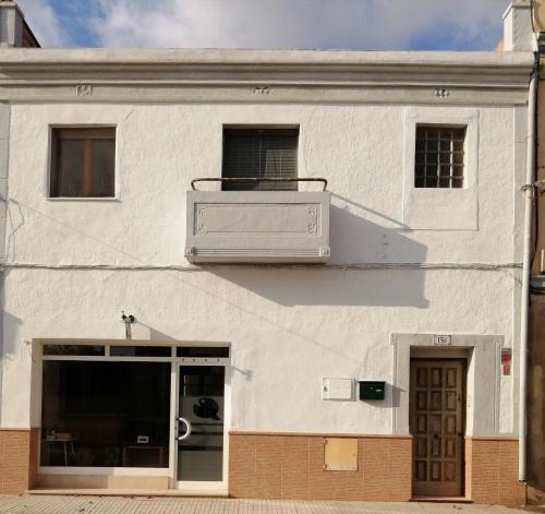 a white building with a balcony on top of it at Can Ventura in Deltebre