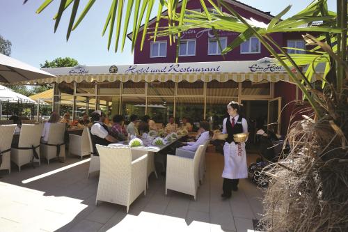 a woman standing in front of a table with food at Eden Hotel in Bad Krozingen