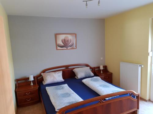 a bedroom with a bed with a blue bedspread at Albergo Restaurante Da Franco in Büchenbeuren