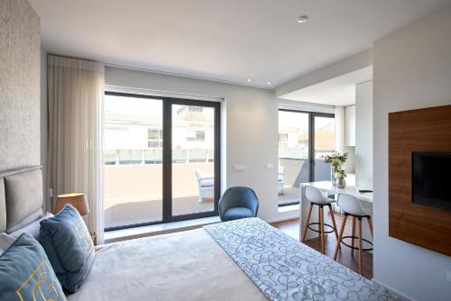 a bedroom with a bed and a view of a balcony at Signature Apartments Santa Catarina in Porto