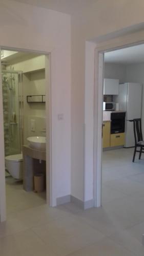 a white bathroom with a sink and a kitchen at Holiday Home with Sea View in Vrbnik