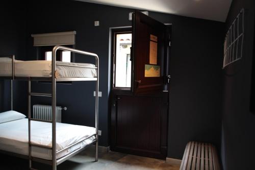 a room with two bunk beds and a door at Casa Carmina Hostel in Muros de Nalón
