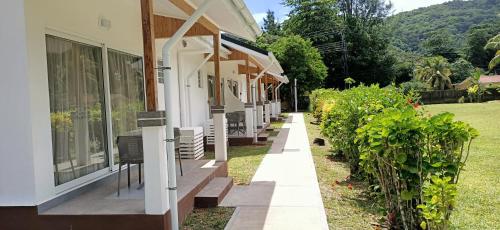 a building with a row of windows next to a yard at Le Relax Beach Resort in Grand'Anse Praslin